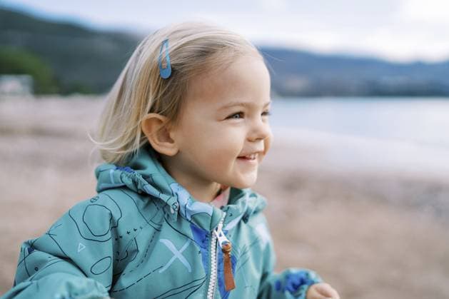 Creative Highlight Symbolbilder Ein kleines lächelndes Mädchen steht am Strand und schaut weg Little smiling girl stands on the beach and looks away. Copyright: imageBROKER NadtochiyxVladimir ibxiqx13182216.jpg ,model released, Symbolfoto ,property released