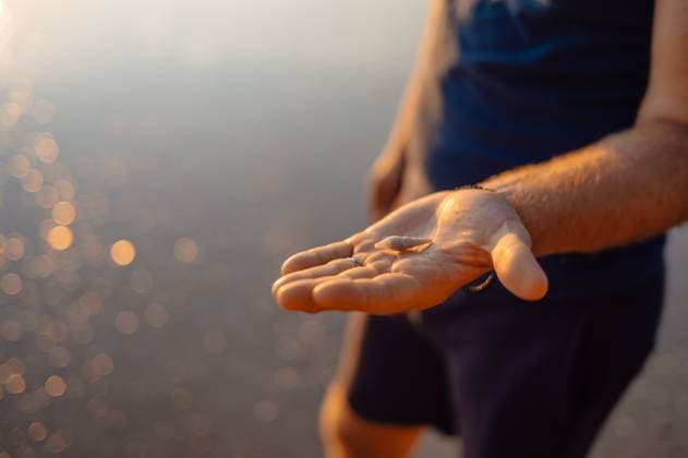 Creative Highlight Symbolbilder Male Hand Holding Tiny Shell at Ao Nang Beach During Golden Light Ao Nang, Krabi, Thailand R_EPZT250506-1718827-01 ,model released, Symbolfoto
