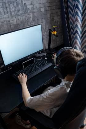IMAGO Creative, Lifestyle, Gaming A teenage boy wearing headphones plays a video game on a desktop PC. The setup includes a wide monitor and gaming peripherals, creating an immersive experience at home Model Released Ikvyatkovskaya_ID28180_830154_021 Copyright: xIkvyatkovskayax RECORD DATE NOT STATED