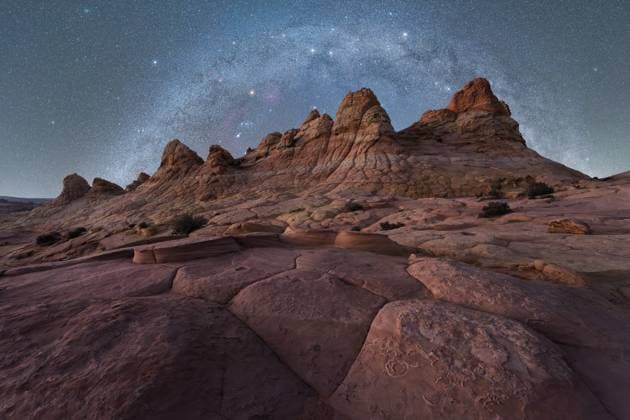 Creative Highlights World A breathtaking view of jagged rock formations under a vast, starry night sky, capturing the beauty of a remote desert landscape in Coyote Buttes, Arizona. Perfect for nature and travel enthusiasts. Model Released JuanLopez_ID28387_836222_012 Copyright: xJuanxLopezx