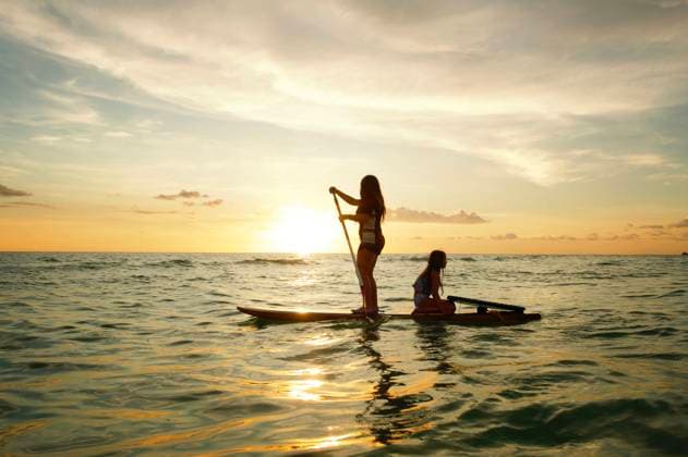 Creative Highlight Symbolbilder Profile teen sisters paddleboarding in Gulf of Mexico at sunset Anna Maria, Florida, United States CR_JOKU250508-1722522-01 ,model released, Symbolfoto
