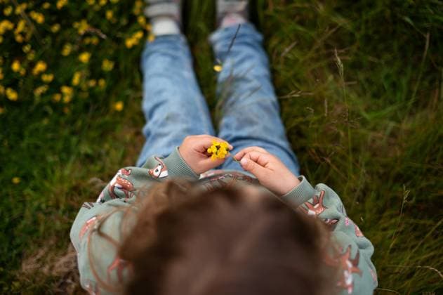 Creative Highlight Symbolbilder view from above the girl holds a yellow flower in her hands Corby, England, United Kingdom CR_JNDO250511B-1724967-01 ,model released, Symbolfoto
