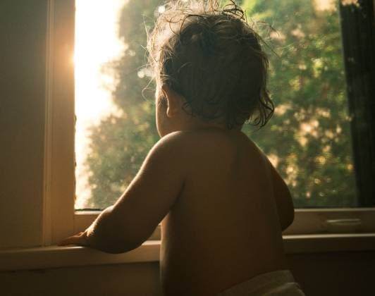 Creative Highlight Symbolbilder Evening Contemplation: Child by a Window at Sunset Saint Paul, Minnesota, United States R_WDJM250508-1723029-01 EDITORIAL USE ONLY
