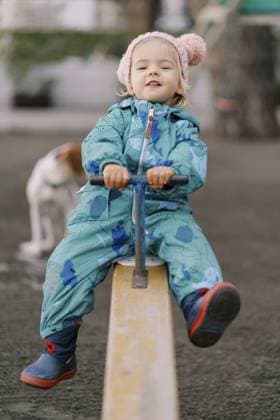 Creative Highlight Symbolbilder Ein lächelndes kleines Mädchen schwingt auf einem Schaukelbalancer, hält den Griff fest und lehnt sich zurück Smiling little girl swings on a swing-balancer, holding the handle and leaning back. Copyright: imageBROKER NadtochiyxVladimir ibxiqx13182327.jpg ,model released, Symbolfoto ,property released
