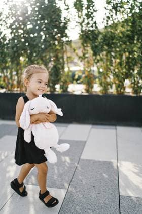 Creative Highlight Symbolbilder Ein kleines lächelndes Mädchen geht und umarmt einen großen rosa Spielzeughasen Little smiling girl walks hugging a big pink toy hare. Copyright: imageBROKER NadtochiyxVladimir ibxiqx13182606.jpg ,model released, Symbolfoto ,property released