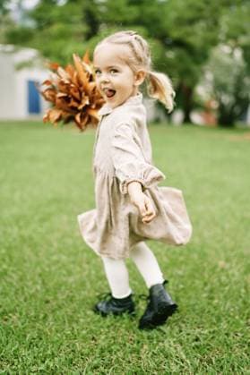 Creative Highlight Symbolbilder Kleines glückliches Mädchen mit einem Strauß orangefarbener Blätter wirbelt durch den Park Little happy girl with a bouquet of orange leaves spins around the park. Copyright: imageBROKER VolodymyrxNadtochii ibxiqx13182624.jpg ,model released, Symbolfoto ,property released