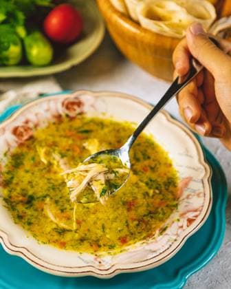 Person hält Löffel mit Hühnersuppe über Schüssel Person hält Löffel mit Hühnersuppe über Schüssel (License=RF) Copyright: xZoonar.com FarhadxIbrah?mzadex 23382336