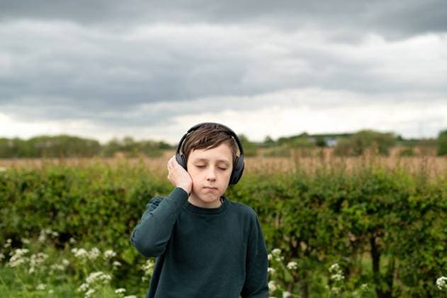 Creative Highlight Symbolbilder Teen age boy listening music with headphones, closed eyes, in nature. Corby, England, United Kingdom R_JNDO250512-1726003-01 ,model released, Symbolfoto