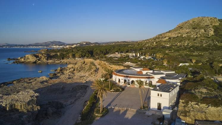 Drohnenaufnahme, Morgenlicht, Rundes Gebäude in einer felsigen Mittelmeerlandschaft, umgeben von Bäumen, mit Blick auf das blaue Meer und klaren Himmel, Kalithea, Kallithea, Thermen, Thermalbad, Badeanlage, Rhodos, Dodekanes, Griechische Inseln, Griechenland, Europa Drone shot, morning light, Round building in a rocky Mediterranean landscape, surrounded by trees, overlooking the blue sea and clear sky, Kalithea, Kallithea, thermal baths, spa, Rhodes, Dodecanese, Greek Islands, Greece, Europe Copyright: imageBROKER RalfxAdler ibxraa13582903.jpg
