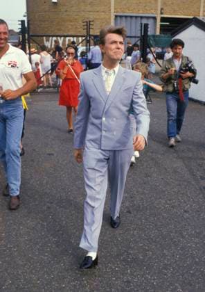At Battersea Heliport on the day of the Live Aid concert DAVID BOWIE At Battersea Heliport on the day of the Live Aid concert, London, England, 13th July 1985 full length blue grey suit black shoes white shirt tie teeth quiff hair walking CAP PL Phil Loftus London Great Britain Copyright: xPhilxLoftus CapitalxPicturesx