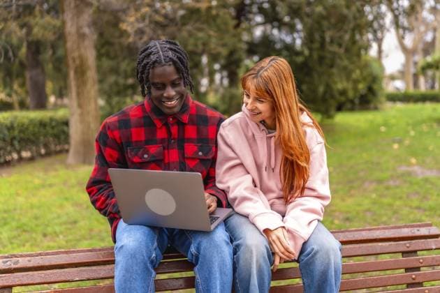 Zwei College Studenten arbeiten gemeinsam an einem Projekt, benutzen einen Laptop in einem Park, genießen das schöne Wetter und tauschen ihr Wissen aus Two college students collaborating on a project, using laptop in a park, enjoying the pleasant weather and sharing knowledge Copyright: imageBROKER UnaixHuizi ibxuhu13586275.jpg ,model released, Symbolfoto ,property released