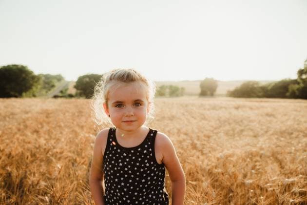 Creative Highlights Symbolbilder Young girl softly smiling in a Kansas wheat field Concordia, Kansas, United States CR_ZMDZ250515B4-1730650-01 ,model released, Symbolfoto