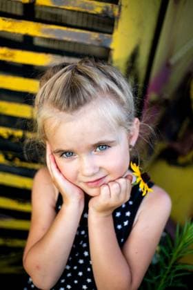 Creative Highlights Symbolbilder Young girl leans on antique yellow truck holding a flower Concordia, Kansas, United States R_ZMDZ250515B4-1730597-01 ,model released, Symbolfoto