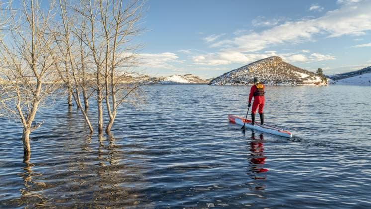 Männlicher Paddler in einem Trockenanzug und einer Schwimmweste paddelt auf einem langen Stand Up Paddleboard bei winterlichen Bedingungen auf einem See in Colorado Horsetooth Reservoir, Fitness und Trainingskonzept Male paddler in a drysuit and life jacket is paddling a long racing stand up paddleboard in winter conditions on a lake in Colorado - Horsetooth Reservoir, fitness and training concept Copyright: imageBROKER MarekxUliasz ibxiqx13544275.jpg ,model released, Symbolfoto ,property released