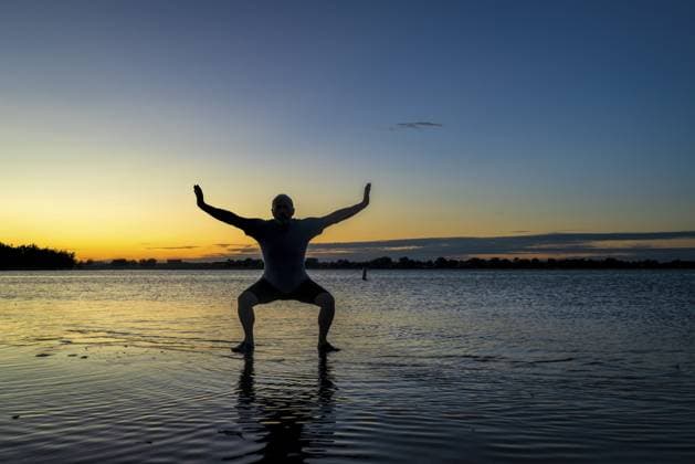 Sonnenaufgangssilhouette eines Mannes, der im flachen Wasser steht und Chigong oder Tai Chi Bewegungen praktiziert, Boyd Lake State Park im Norden Colorados Sunrise silhouette of a man standing in shallow water and practicing chigong or tai chi movements, Boyd Lake State Park in northern Colorado Copyright: imageBROKER MarekxUliasz ibxiqx13541861.jpg ,model released, Symbolfoto ,property released