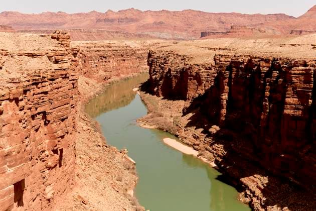 Creative Highlights World Majestic canyon with towering red rock cliffs and a winding green river below under a clear sky. Road Trip USA United States bola08867 Copyright: xConnectxImagesx