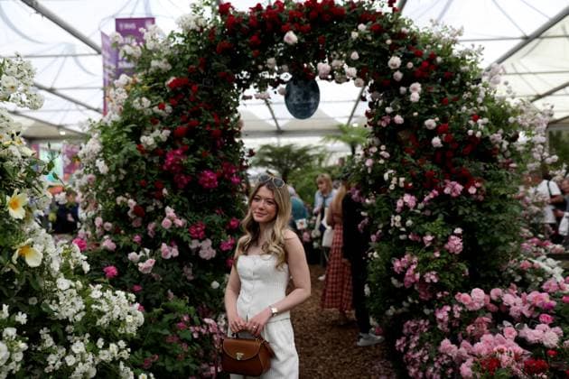 (250521) -- LONDON, May 21, 2025 -- A woman poses for photos at the RHS (Royal Horticultural Society) Chelsea Flower Show in London, Britain, on May 20, 2025. The annual show opened to the public here on Tuesday. ) BRITAIN-LONDON-RHS CHELSEA FLOWER SHOW LixYing 