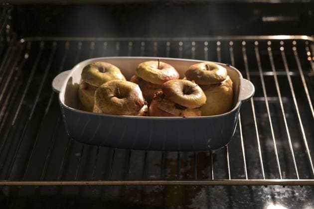 Dampfende Bratäpfel im Ofen, gefüllt mit Mandeln, Honig und Zimt, Vorbereitung für ein Festtagsdessert zu Thanksgiving, Weihnachten oder Neujahr, Kopierraum, ausgewählter Fokus Steaming baked apples in the oven, stuffed with almonds, honey and cinnamon, preparation for a holiday dessert on thanksgiving, Christmas or new year, copy space, selected focus Copyright: imageBROKER MarenxWinter ibxiqx11195243.jpg