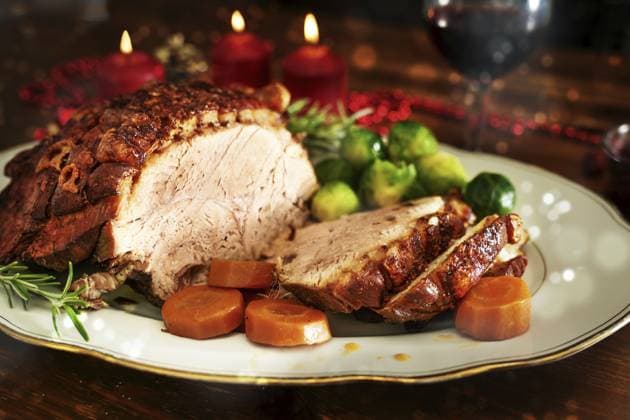 Weihnachtsschinken oder Schweinebraten mit knuspriger Fettkruste, serviert mit Gemüse auf einem dunklen Holztisch mit Kerzen und Bokeh Blasen, gewählter Fokus, geringe Tiefenschärfe Christmas ham or roast pork with crispy fat crust, served with vegetables on a dark wooden table with candles and bokeh bubbles, selected focus, narrow depth of field Copyright: imageBROKER MarenxWinter ibxiqx11195246.jpg