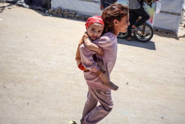 News Themen der Woche KW21 News Bilder des Tages Hamas Israel Conflict A Palestinian displaced girl carries her sister at a camp for displaced people in Gaza City, Palestine, on May 21, 2025, amid the ongoing war between Israel and the Palestinian militant movement Hamas. Israel, pressing a newly expanded military offensive across the Gaza Strip, faces mounting pressure, including from key backer the United States, to end the aid blockade it imposes on March 2. Gaza Palestine  Copyright: xMajdixFathix originalFilename: fathi-notitle250521_npZIV.jpg