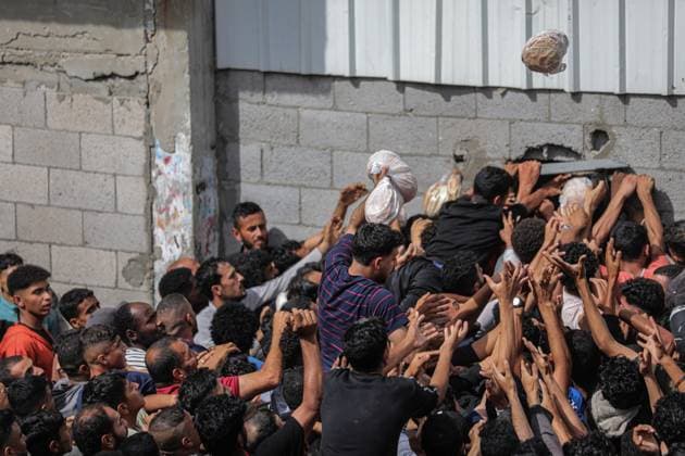 Bilder des Jahres 2025, News 05 Mai News Themen der Woche KW21 Displaced Palestinians reach out for bread being distributed through a bakery window in Nusseirat Refugee Camp after limited flour supplies entered the Gaza Strip Displaced Palestinians reach out for bread being distributed through a bakery window in Nusseirat Refugee Camp after limited flour supplies entered the Gaza Strip, where severe restrictions on humanitarian aid have remained in place since March 2, in Gaza on May 22, 2025. Photo by Ahmed Ibrahim apaimages Nusseirat Gaza Strip Palestinian Territory 220525_Nusseirat_AI_00(4) Copyright: xapaimagesxAhmedxIbrahim xapaimagesx
