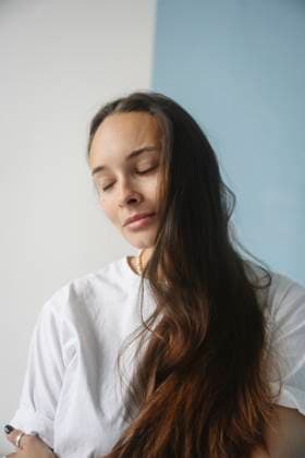 Creative Highlights Symbolbilder Portrait of a woman with long brown hair and closed eyes indoors model released, Symbolfoto property released, EYAF03355