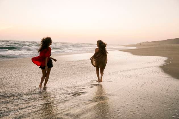 Two women running on the beach at sunset enjoying their holiday model released, Symbolfoto property released, FLMZF00545