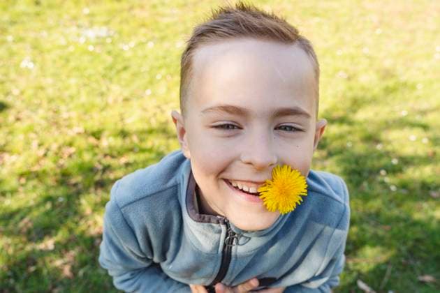 Creative Highlights Symbolbilder Smiling boy with a dandelion flower outdoors on a sunny day model released, Symbolfoto, IHF02201
