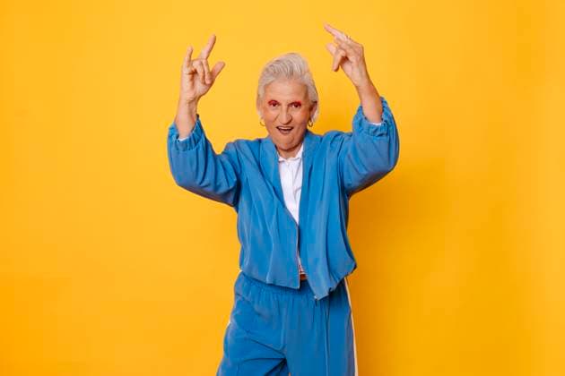 Creative Highlights Symbolbilder Energetic senior woman in blue tracksuit posing against a yellow background model released, Symbolfoto, TCEF02331