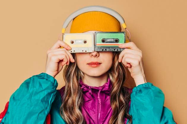 Creative Highlights Symbolbilder Woman in 80s tracksuit hiding face with cassettes and wearing headphones model released, Symbolfoto, VSNF03113