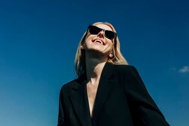 Creative Highlights Symbolbilder Smiling woman in sunglasses under blue sky model released, Symbolfoto, VSNF03123