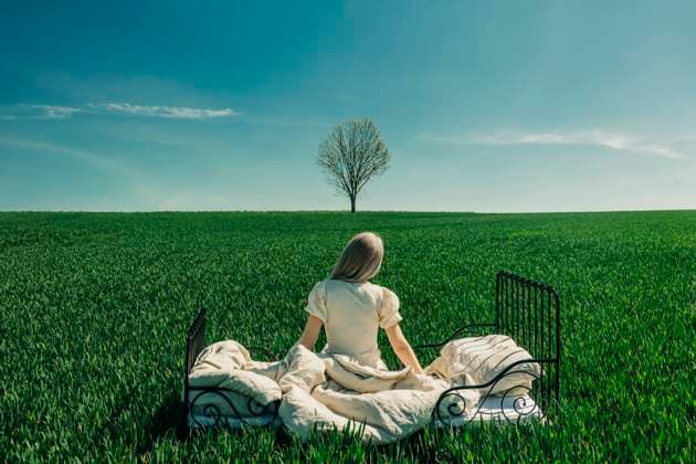 Creative Highlights Symbolbilder Woman sitting on a bed in a green field under a blue sky model released, Symbolfoto, VSNF03153
