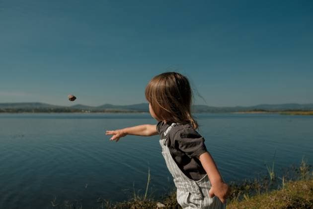 Creative Highlights Symbolbilder Toddler Boy Throwing Rock into Lake in Mexico San Miguel de Allende, Guanajuato, Mexico R_WDJM250526-1739041-01 ,model released, Symbolfoto