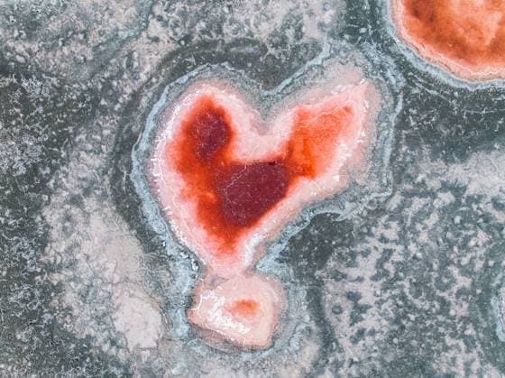 Creative Highlights World Top view, an aerial view captures a unique heart shaped salt formation in the Salar de Antofalla, located in Catamarca, Argentina. This striking natural feature is highlighted by the contrasting colors and textures of the surrounding salt flat. Model Released JuanLopez_ID28689_847773_008 Copyright: xJuanxLopezx
