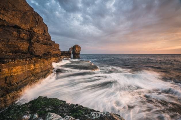 Creative Highlights World Pulpit Rock at sunset with waves at Portland Bill Lighthouse, Portland, Dorset, UK Copyright: JohnxAlexander 1199-677