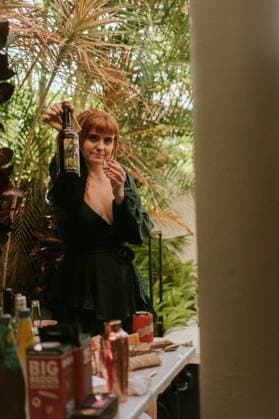 IMAGO Creative, Lifestyle, Feste im Garten #2 Woman showing bottle and shot glass at garden party Sunshine Coast, Queensland, Australia R_YUKI250529B-1697873-01 EDITORIAL USE ONLY