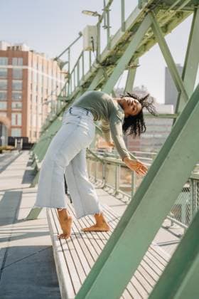 Creative Highlights Symbolbilder Woman arches back in dramatic pose on bench beneath city bridge New York, New York, United States CR_FKNH2506029D-1705752-01 ,model released, Symbolfoto