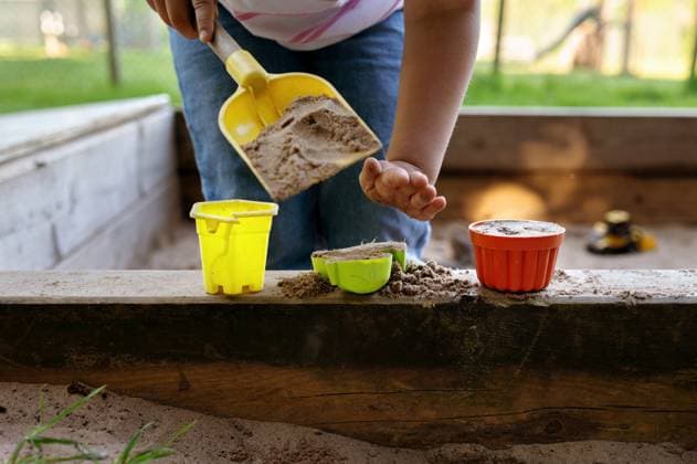 IMAGO Creative, Sommer, Sommertage im Garten Child playing in sandbox with toy buckets and shovel. Corby, England, United Kingdom R_JNDO250603B-1745573-01 ,model released, Symbolfoto