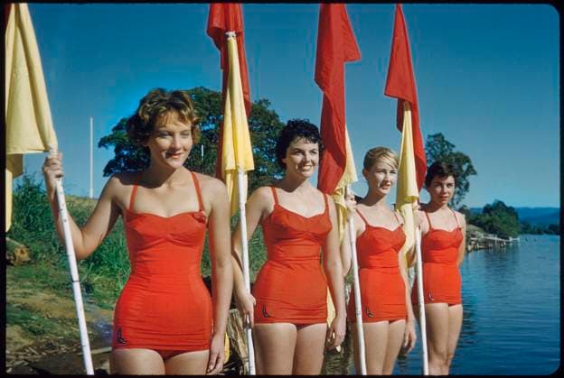 Archivbilder der Woche KW23 Four Young Adult Women Wearing Red One-Piece Bathing Suits and Holding Red and Yellow Flags, Australia, 1960  Copyright: xABxArchivesx jtv009647