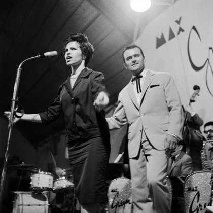 Inge Brandenburg, Max Greger Inge Brandenburg und Max Greger auf der Bühne während eines Konzerts im Münchner Kongress-Saal, 1961. Die Sängerin performt leidenschaftlich am Mikrofon, Greger steht direkt hinter ihr vor der Big Band. Auf Zuruf von Fotograf Klaus Redenbacher hat sich Bandleader Max Greger umgedreht zum Publikum und so entstand diese schöne Aufnahme. München Deutschland Copyright: KlausxRedenbacher RED_93030000250 EDITORIAL USE ONLY