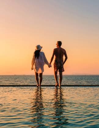 Creative Highlights Symbolbilder Ruhiger Spaziergang bei Sonnenuntergang am Infinity-Pool auf der Insel Koh Munnork in Thailand für Paare A couple enjoys a romantic stroll by the infinity pool at Koh Munnork Island in Rayong, Thailand, as the sun sets, illuminating the water and creating a magical atmosphere. (License=RF) ,model released, Symbolfoto Copyright: xZoonar.com FokkexBaarssenx 23428331 ,model released, Symbolfoto ,property released
