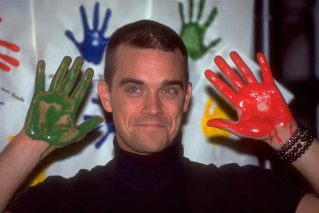 Archivbilder der Woche KW24 Convention Photocall at The Museum Of Childhood ROBBIE WILLIAMS Convention Photocall at The Museum Of Childhood, London, England, 17th November 1999. portrait headshot hands paint covered funny black polo neck top CAP HT Hugh Thompson London Great Britain Copyright: xHughxThompson CapitalxPicturesx