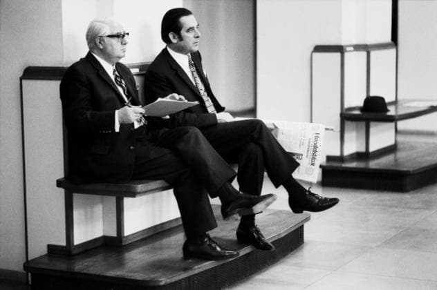 Hamburg, Januar 1972 Zwei Herren in Anzug und Krawatte sitzen nebeneinander auf einer schlichten Holzbank am Rand des Börsensaals der Hamburger Wertpapierbörse. Der linke Mann ist weißhaarig, trägt eine Brille und hält ein Notizbuch oder Börsenverzeichnis in den Händen. Der jüngere Mann neben ihm mit zurückgekämmtem Haar hält eine Ausgabe der Wirtschaftszeitung Handelsblatt auf dem Schoß. Hamburg Hamburg Deutschland *** Hamburg, January 1972 Two Men in Suit and Tie sit side by side at a Finishing Wooden bench on Edge of Trading floor the Hamburg Stock Exchange the Left Man is white-haired, carries a Glasses and holds a Notebook Or Stock exchange directory in the Hands the younger Man next to him with combed back Hair Copyright: xUnitedxArchivesx xSvenxSimonxArchives SVS_94010000629