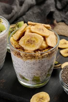 IMAGO Creative, Food, High Protein Frühstück Zwei Gläser mit Chiasamenpudding, eines mit gewürfelter Kiwi und das andere mit Granola und Bananenchips, stehen auf einer dunklen Fläche mit Zutaten Zwei Gläser mit Chiasamenpudding, eines mit gewürfelter Kiwi und das andere mit Granola und Bananenchips, stehen auf einer dunklen Fläche mit Zutaten (License=RF) Copyright: xZoonar.com DANKOxNx 23491245