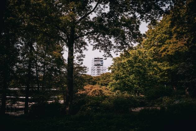 Scenic view of a modern structure framed by lush green trees in an urban park. *** Scenic view of a modern structure framed by lush green trees in an urban park 