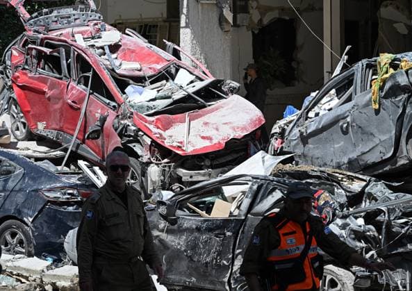 News Themen der Woche KW24 News Bilder des Tages Israeli rescue responders walk past cars destroyed when an Iranian ballistic missile slammed into a residential building in Bat Yam on Sunday, June 15, 2025. At least seven people were killed and hundreds wounded while rescue workers search for missing under the rubble.  JER2025061503 DEBBIExHILL