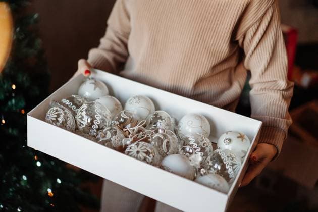 Box with white Christmas tree decorations in woman s hands Milan, Lombardy, Italy R_NEPM250511-1309305-01