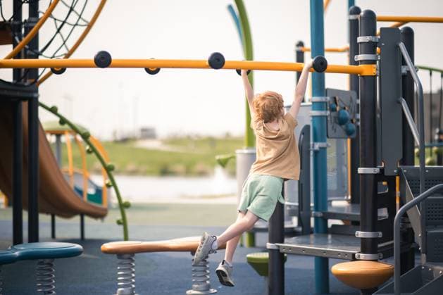 Creative Highlights Symbolbilder Young boy builds strength swinging on colorful monkey bar set Grimes, Iowa, United States CR_LIPF250616-1766955-01 ,model released, Symbolfoto