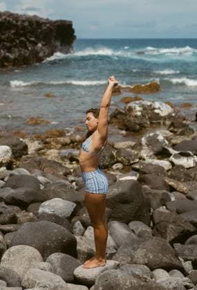 Creative Highlights Symbolbilder Woman Stretching on Rocky Shoreline United States, Hawaii, Paia CR_WXHJ250617-1729501-01 ,model released, Symbolfoto