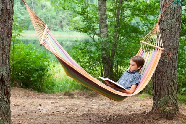 Kind liest Buch in der Hängematte Boy lying in hammock reading a book outdoors (License=RF) ,model released, Symbolfoto Copyright: xZoonar.com DmitryxNaumovx 23626877 ,model released, Symbolfoto ,property released